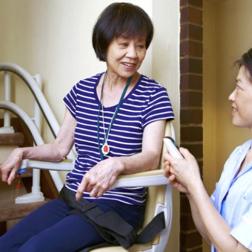 Senior woman on stair lift with nurse